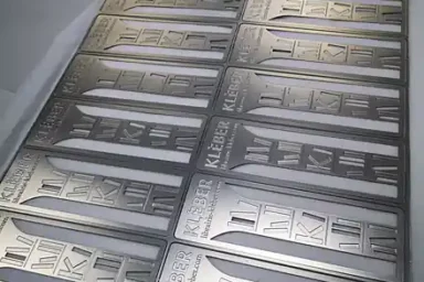 Planches de marque-pages en métal Librairie Kléber, finitions argent et or, avant l'injection de la peinture dans le motif